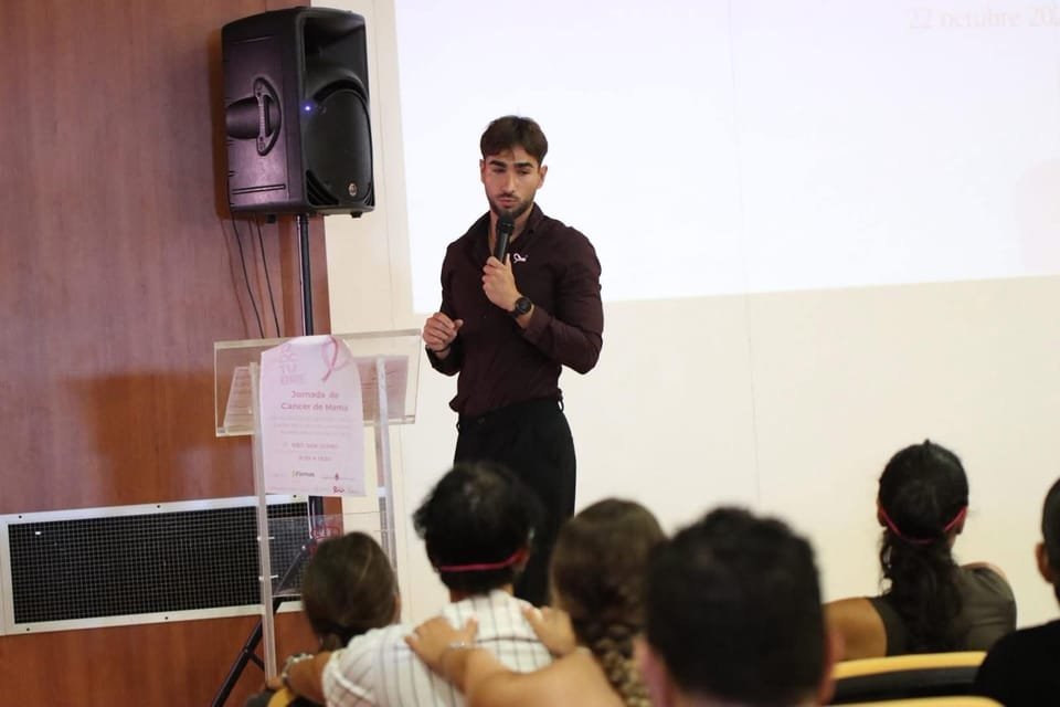 Alex dando una charla en una jornada de cáncer de mama