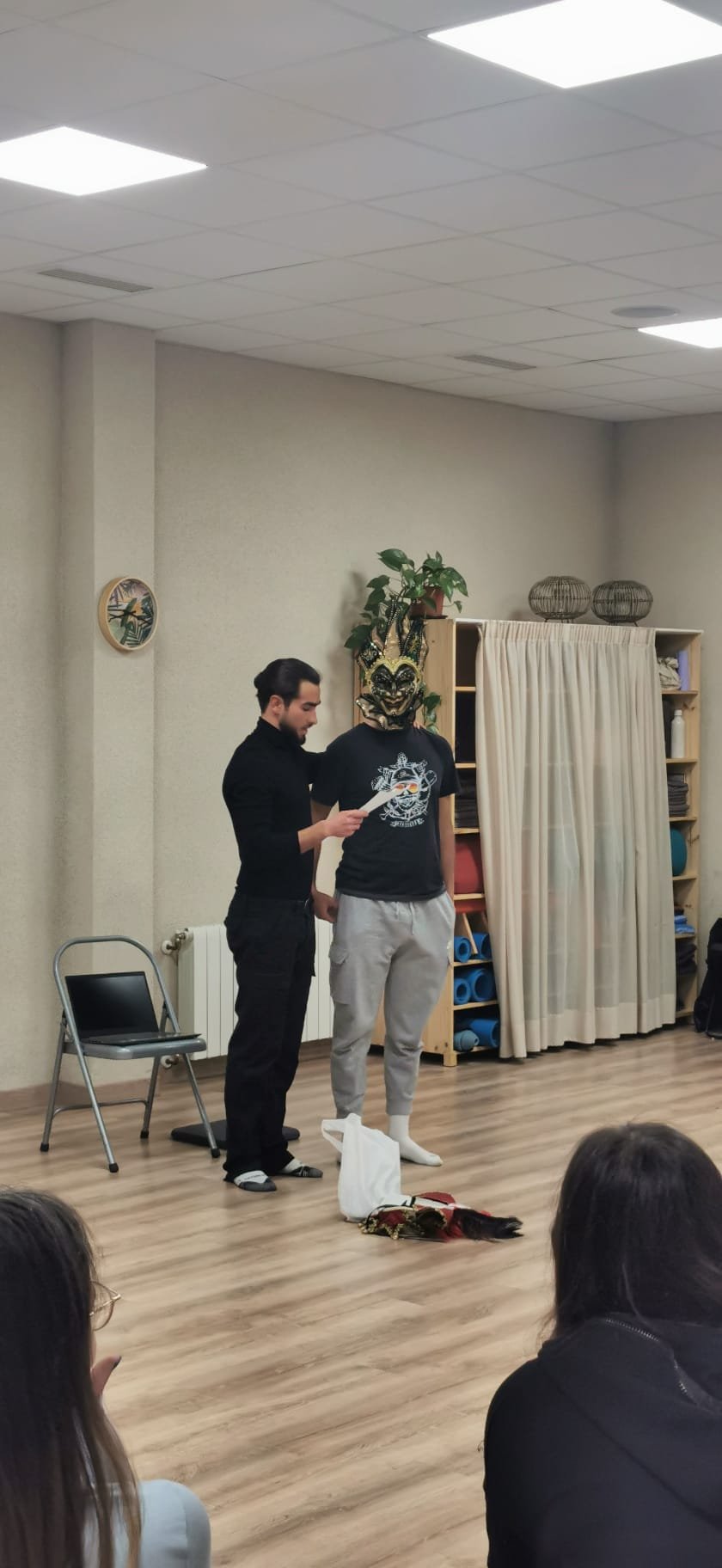 Dinámica experiencial con máscara durante un taller, con el grupo sentado alrededor